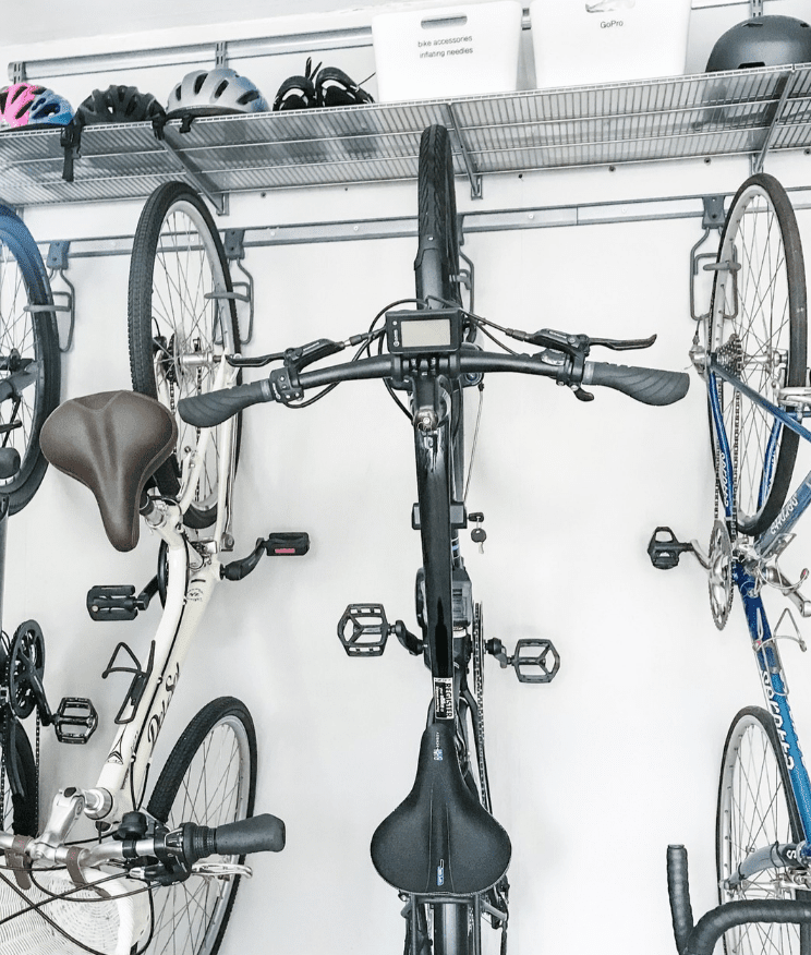 Una pared de garaje con bicicletas colgadas en fila