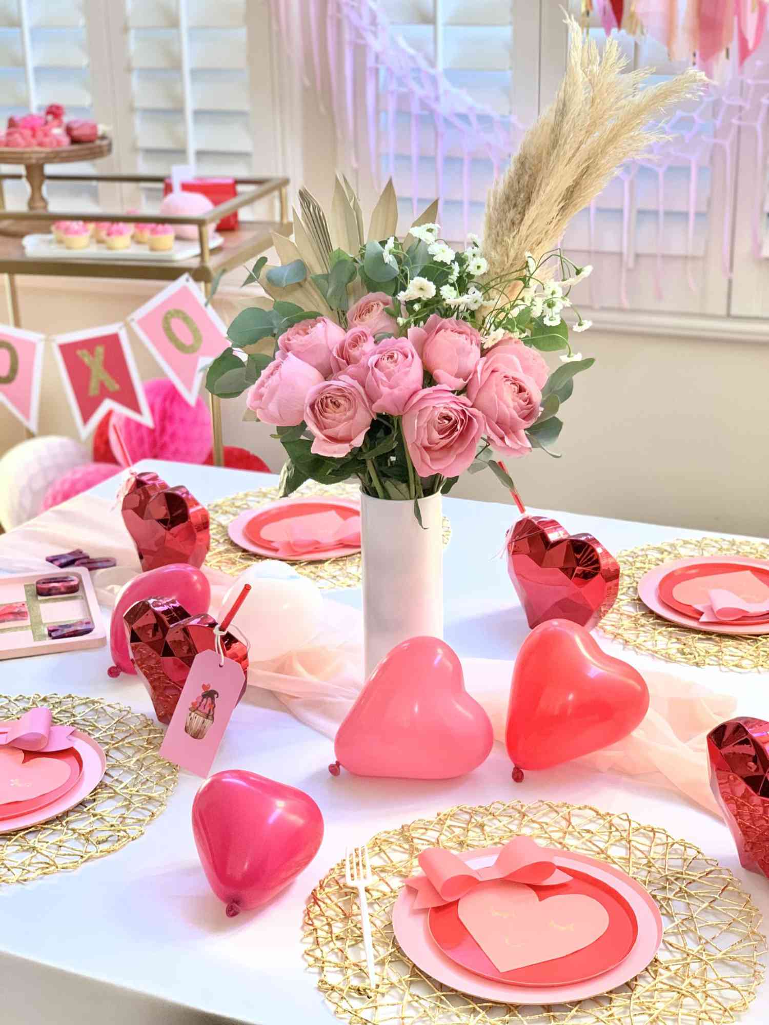 Bright neon pink heart balloons on table with flowers