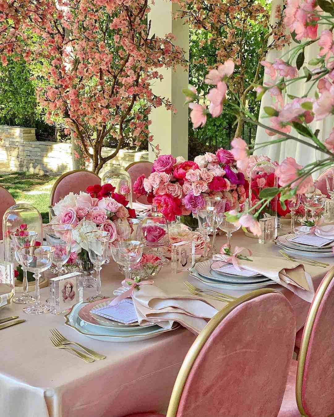 Diferentes flores rosas en una mesa rosa