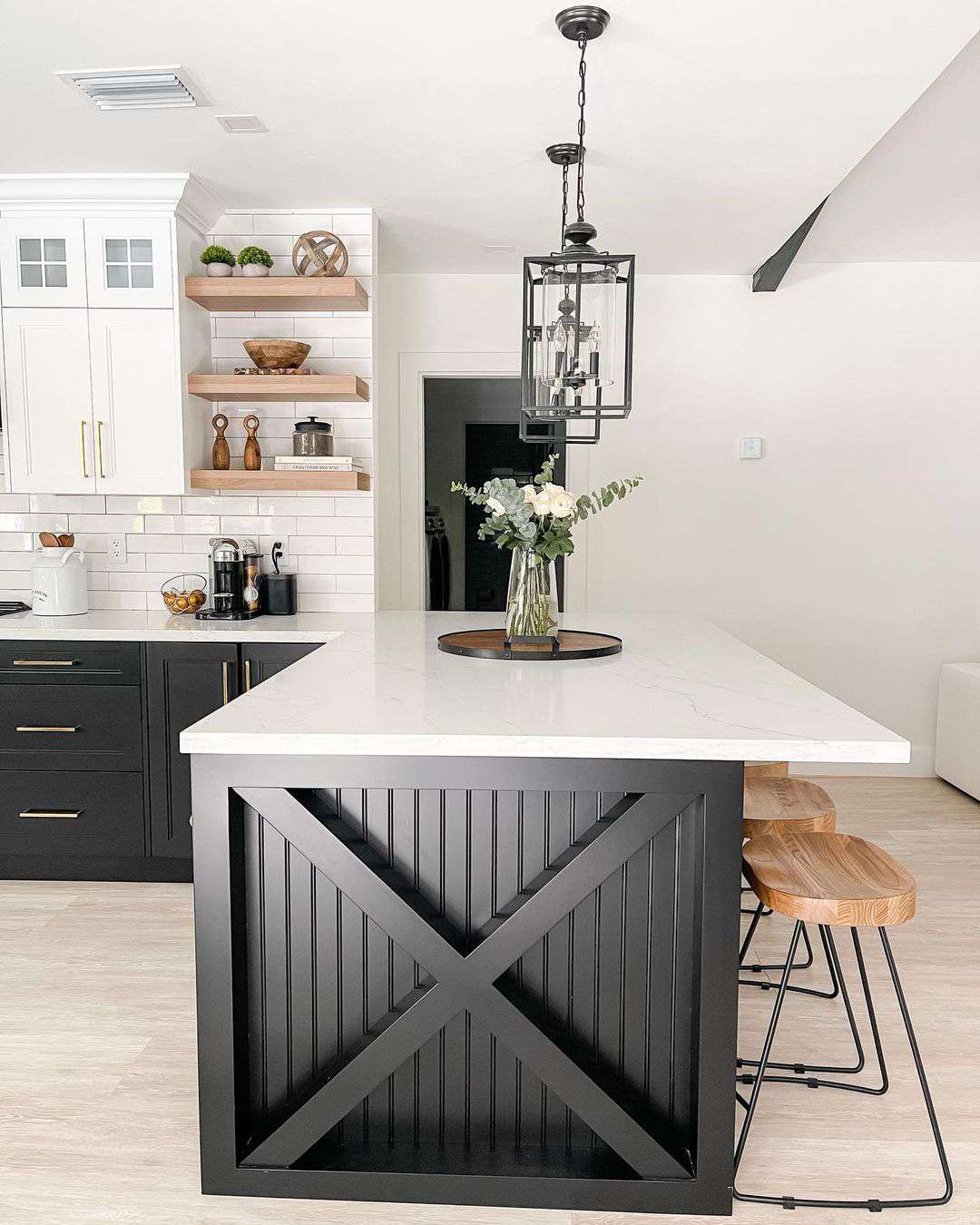 Black shiplap island in a black and white kitchen