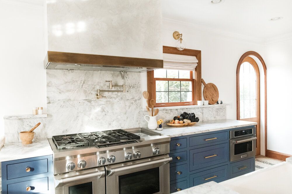 Küche mit handwerklichen Elementen wie Holzfenstern und gewölbter Tür