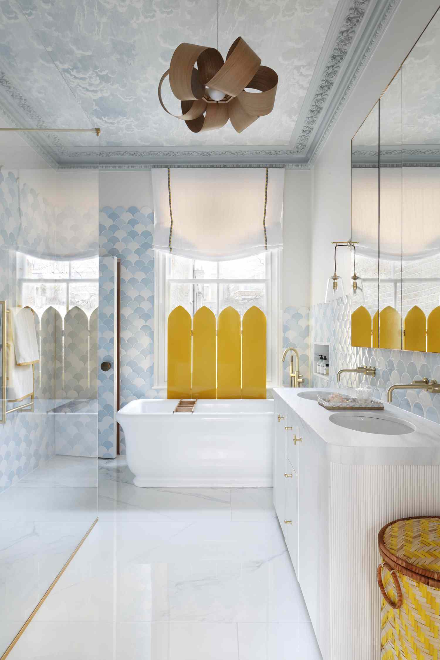 Salle de bain avec carrelage mural bleu clair et papier peint au plafond et store de fenêtre jaune vif