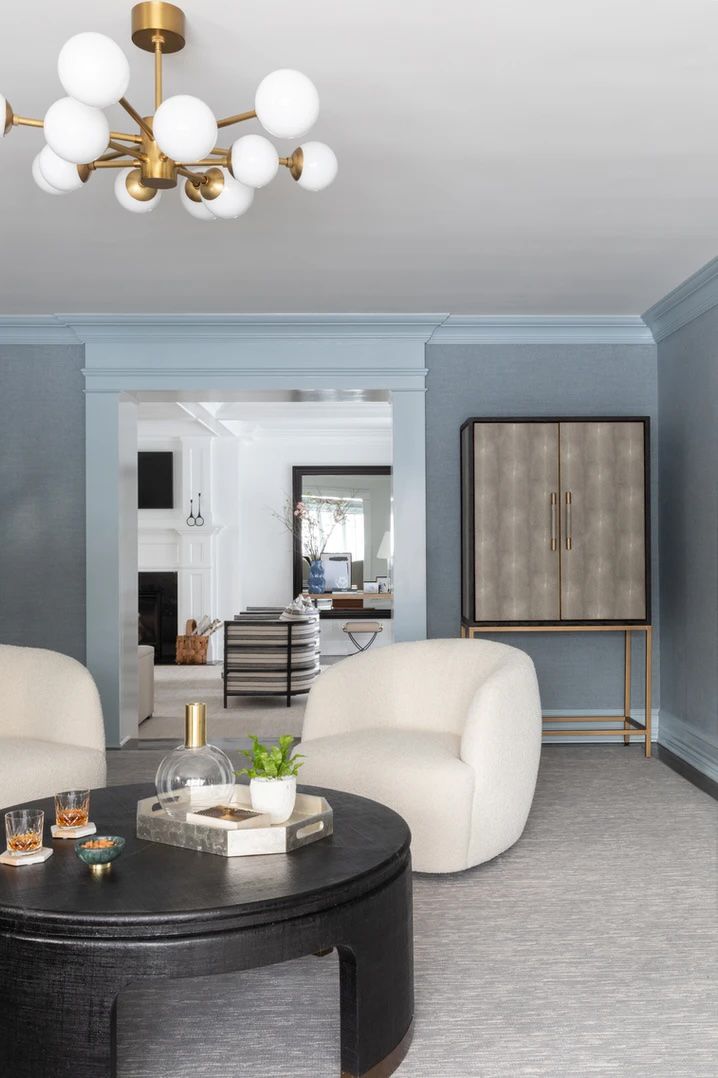 Acabamento azul claro e papel de parede de grama em uma sala de estar formal com móveis de cores neutras
