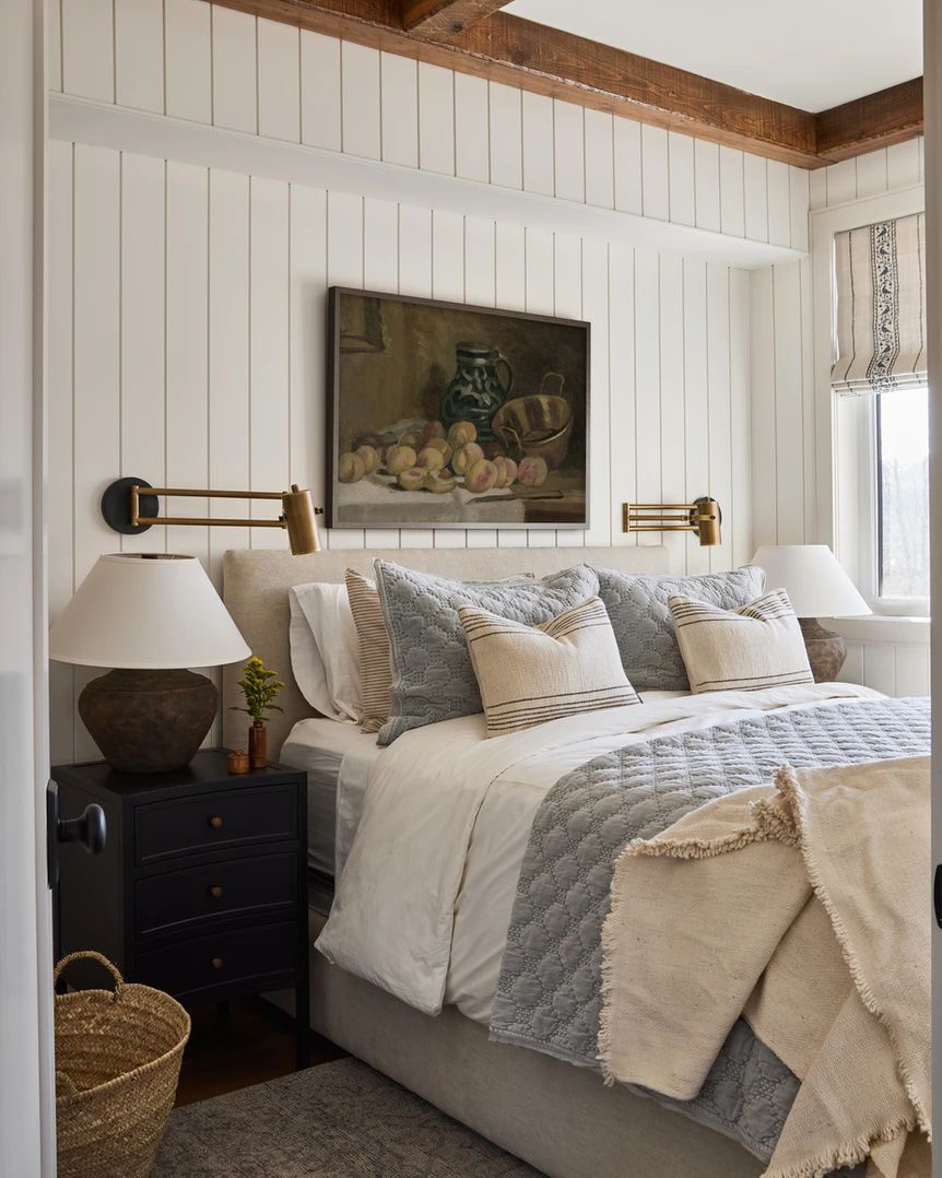 Dormitorio tradicional con paredes de tablilla blanca y vigas de madera