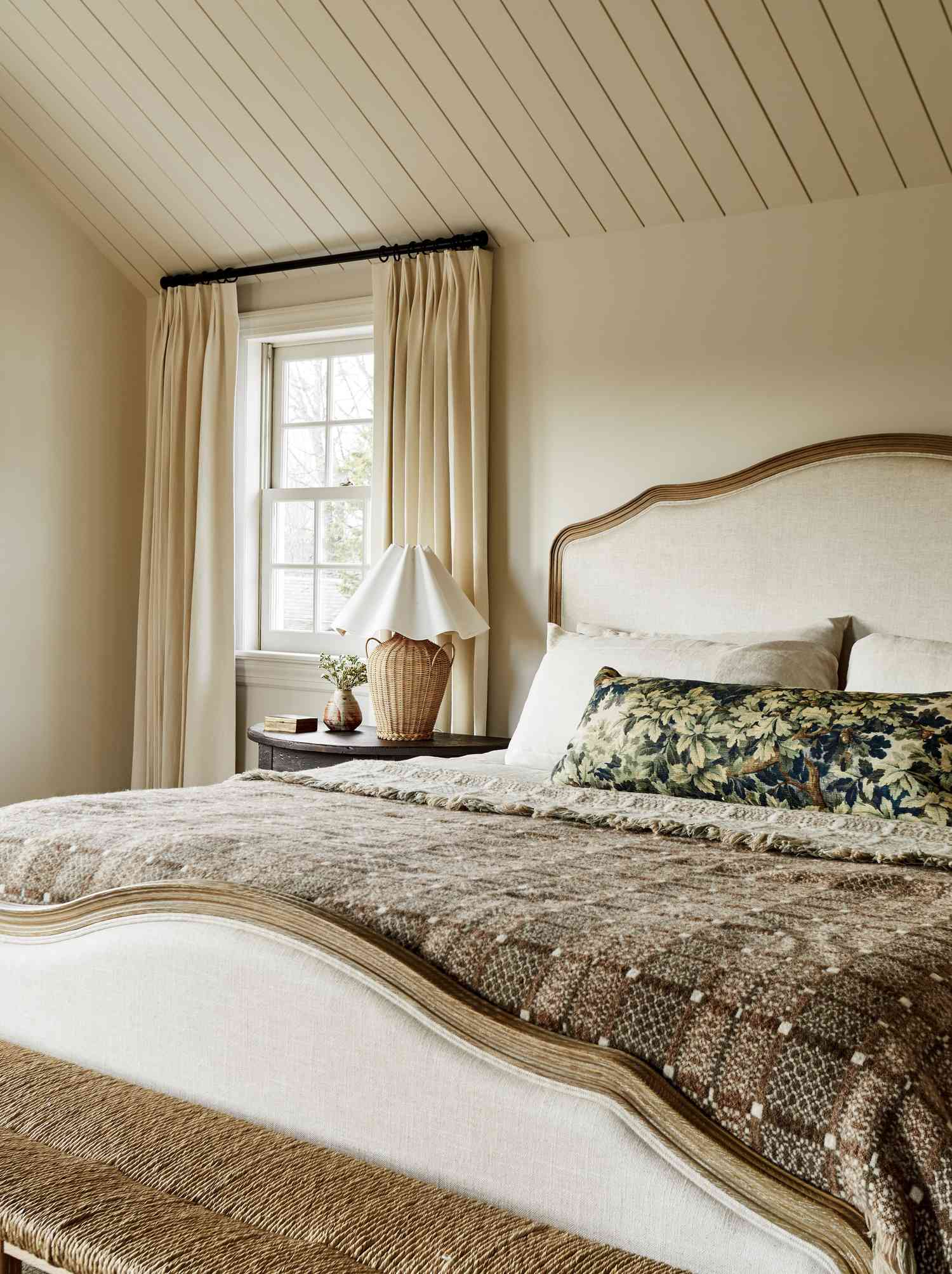 Dormitorio tradicional con paredes crema y shiplap en el techo