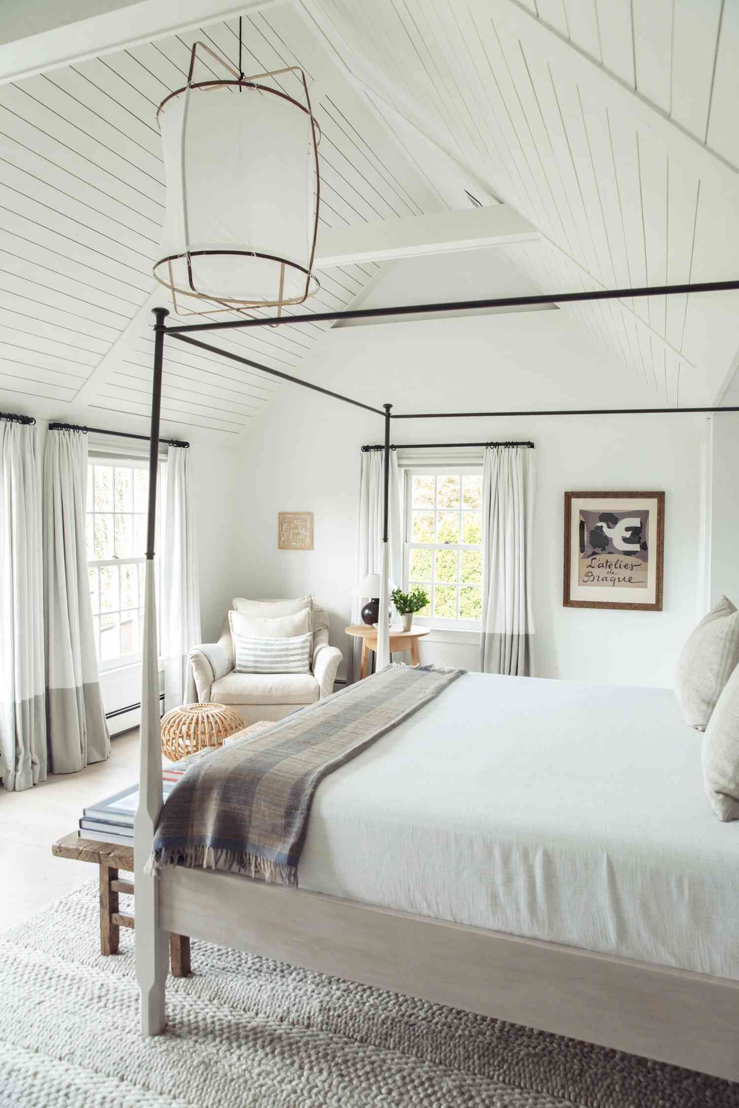 Dormitorio blanco con shiplap en el techo abovedado