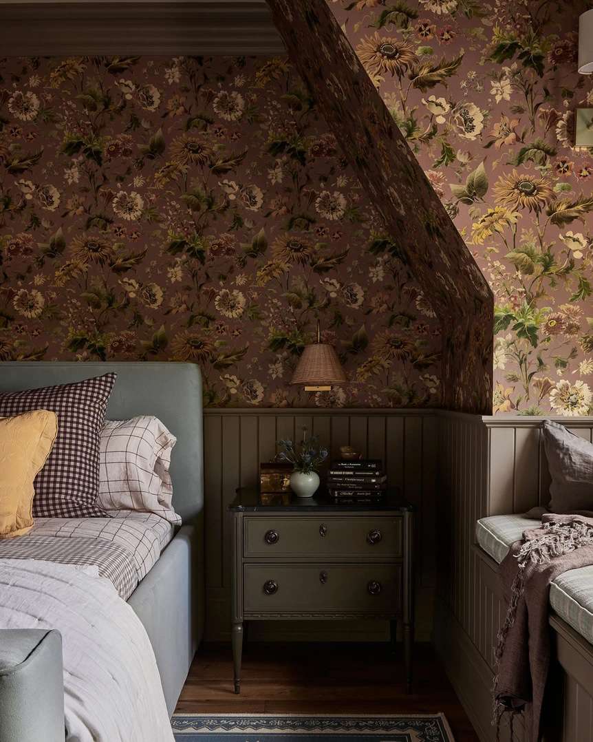 Quarto com papel de parede floral arrojado sobre shiplap escuro