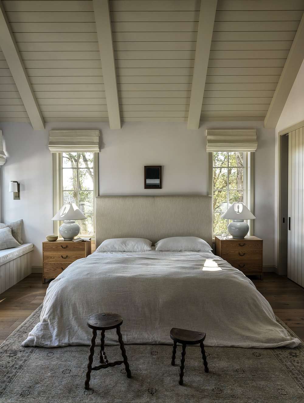 Dormitorio en tonos neutros con techo de shiplap y vigas a juego