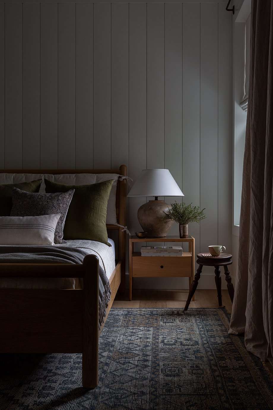 Shiplap vertical en un dormitorio oscuro y taciturno con muebles de madera